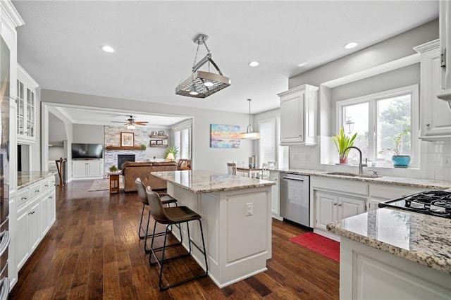 21502 W 98th Ter, Lenexa, KS 66220 - kitchen featuring stainless steel dishwasher, a center island, a fireplace, white cabinets, and recessed lighting