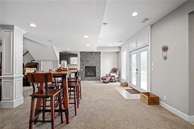 21502 W 98th Ter, Lenexa, KS 66220 - dining space with carpet, recessed lighting, a stone fireplace, stairs, and decorative columns