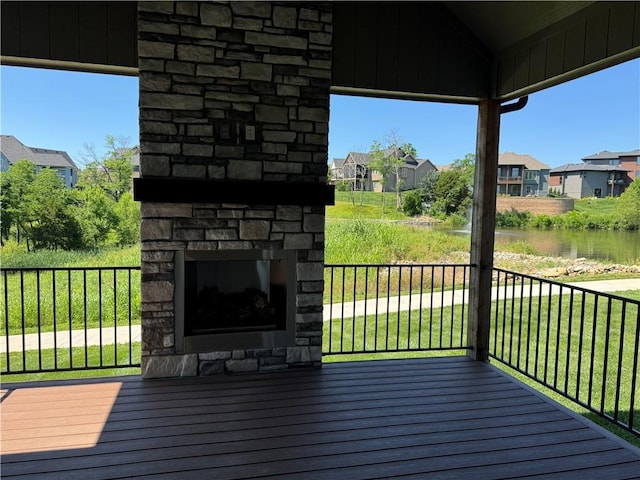 22415 87th Ter, Lenexa, KS 66227 - deck featuring an outdoor stone fireplace, a residential view, a water view, and a yard