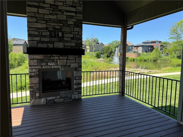 22415 87th Ter, Lenexa, KS 66227 - wooden terrace with an outdoor stone fireplace, a water view, a residential view, and a yard