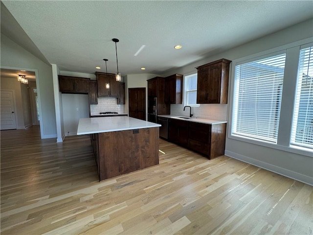 22415 87th Ter, Lenexa, KS 66227 - kitchen with decorative backsplash, dark brown cabinetry, light wood-style floors, recessed lighting, and a textured ceiling