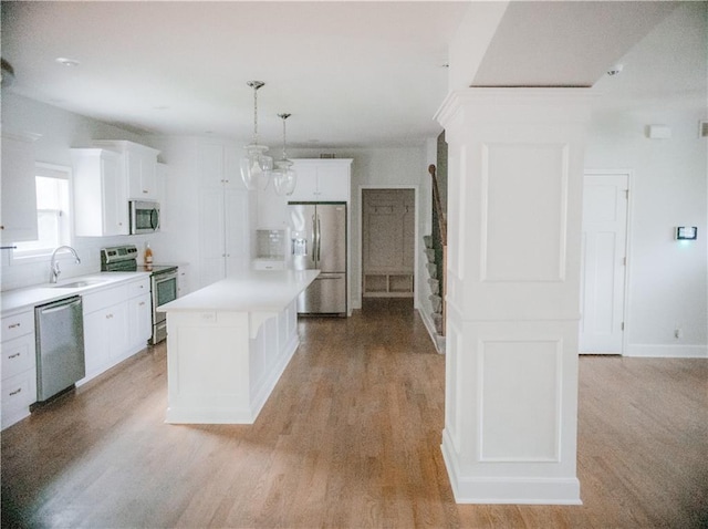 5073 NW Timberline Dr, Riverside, MO 64150 - kitchen featuring appliances with stainless steel finishes, light wood finished floors, white cabinets, light countertops, and a kitchen island