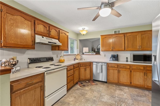 17014 E 45th St S, Independence, MO 64055 - kitchen featuring stainless steel appliances, under cabinet range hood, brown cabinets, tasteful backsplash, and a textured ceiling