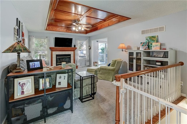 2013 NE Summerfield Ct, Blue Springs, MO 64029 - living room featuring a raised ceiling, ceiling fan, carpet, and a fireplace
