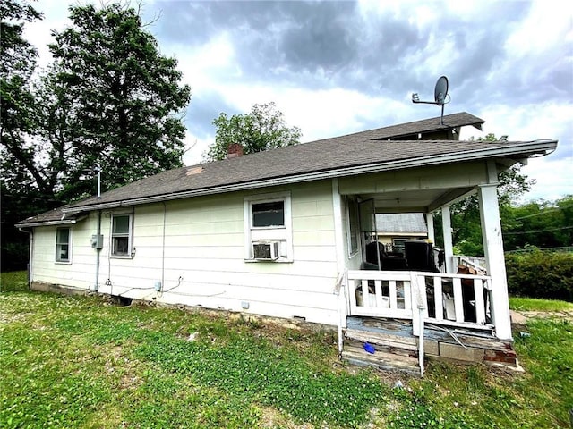 5433 E 29th St, Kansas City, MO 64128 - back of property with a yard, a chimney, and cooling unit