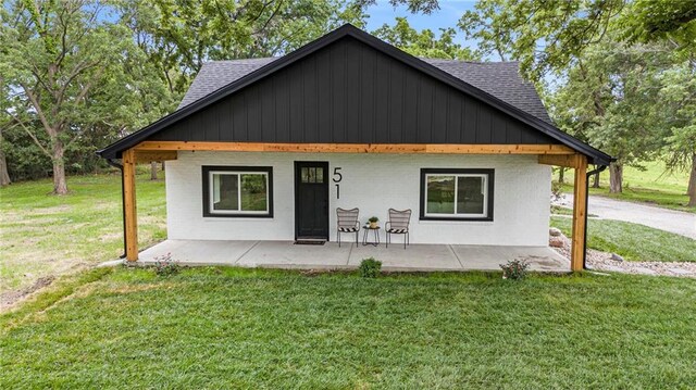51 SE 208th St, Holt, MO 64048 - view of front facade featuring a front yard, roof with shingles, and a patio area