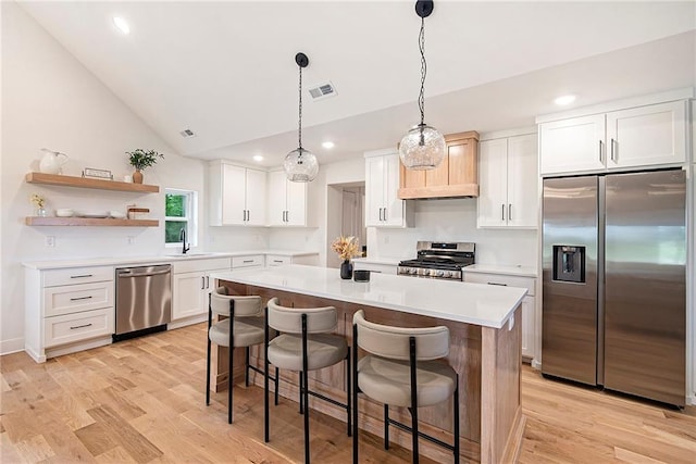 51 SE 208th St, Holt, MO 64048 - kitchen featuring appliances with stainless steel finishes, a center island, light countertops, white cabinets, and a kitchen bar