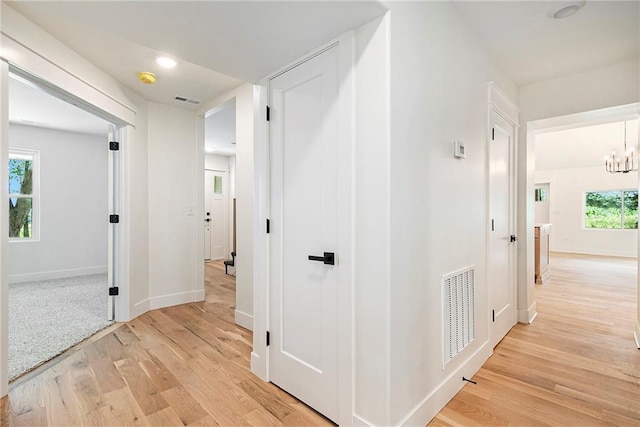 51 SE 208th St, Holt, MO 64048 - hall featuring light wood finished floors and a chandelier