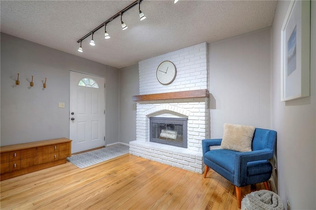 7000 Dearborn St, Overland Park, KS 66204 - entryway with a textured ceiling, wood finished floors, a fireplace, and track lighting