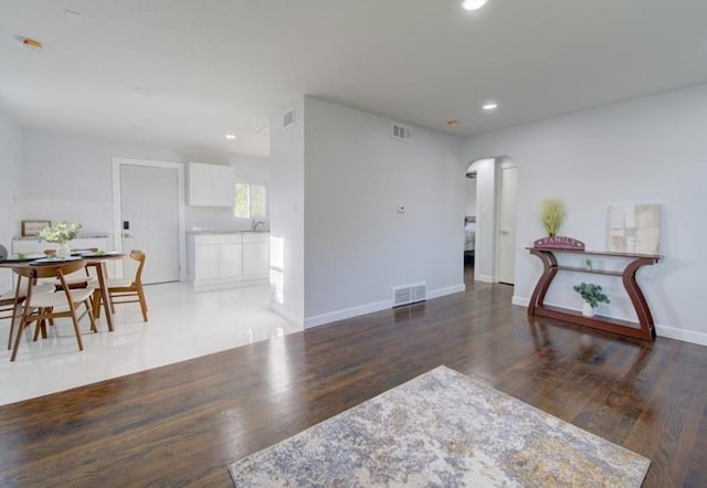 2507 E 69th St, Kansas City, MO 64132 - living area featuring arched walkways, recessed lighting, and wood finished floors