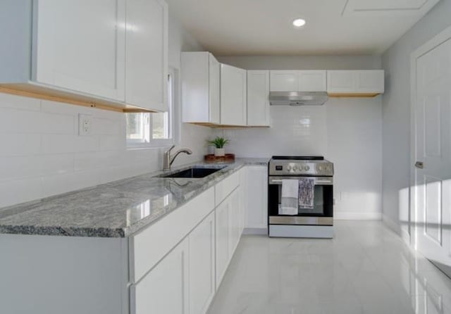 2507 E 69th St, Kansas City, MO 64132 - kitchen featuring stainless steel electric stove, under cabinet range hood, light stone counters, decorative backsplash, and recessed lighting