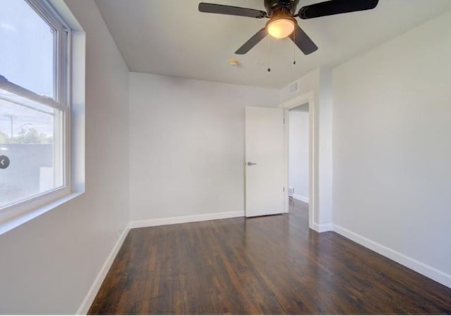 2507 E 69th St, Kansas City, MO 64132 - empty room featuring plenty of natural light, wood finished floors, and a ceiling fan