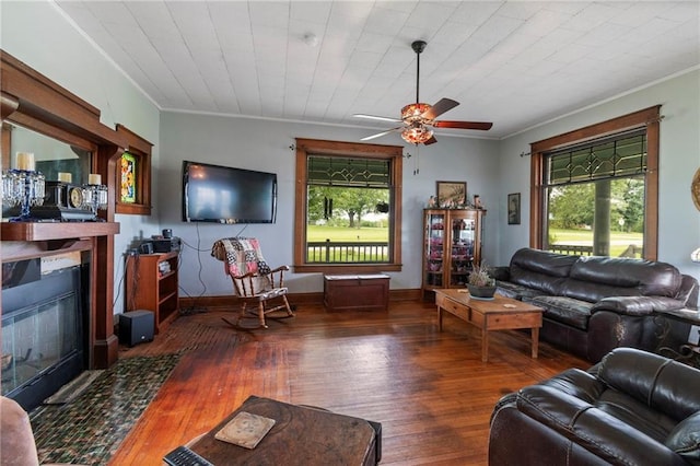 1080 SW 58th Hwy, Holden, MO 64040 - living area featuring ceiling fan, wood-type flooring, plenty of natural light, ornamental molding, and a fireplace with flush hearth