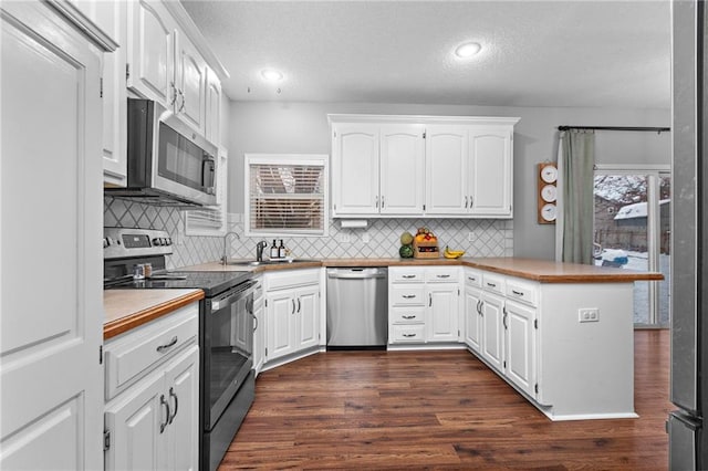 20586 W 220th St, Spring Hill, KS 66083 - kitchen featuring appliances with stainless steel finishes, a peninsula, white cabinetry, a textured ceiling, and decorative backsplash