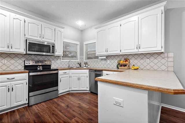 20586 W 220th St, Spring Hill, KS 66083 - kitchen featuring stainless steel appliances, a peninsula, white cabinets, dark wood-style floors, and light countertops