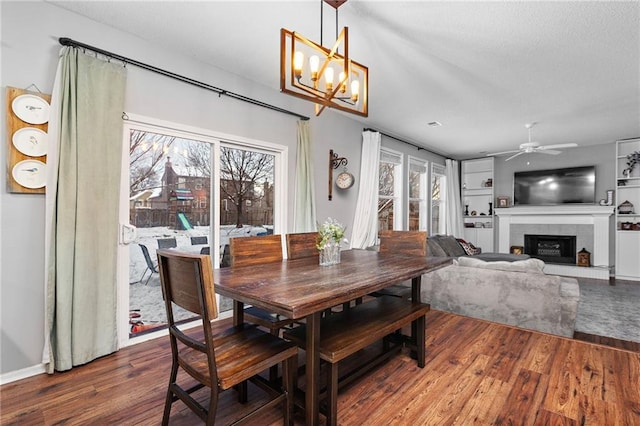 20586 W 220th St, Spring Hill, KS 66083 - dining room with wood finished floors, a fireplace, a chandelier, and ceiling fan