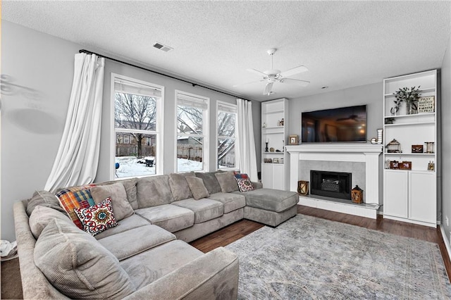 20586 W 220th St, Spring Hill, KS 66083 - living area with a textured ceiling, ceiling fan, dark wood-type flooring, and a fireplace