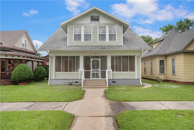 704 Lincoln St, Coffeyville, KS 67337 - bungalow with a sunroom, roof with shingles, and a front lawn