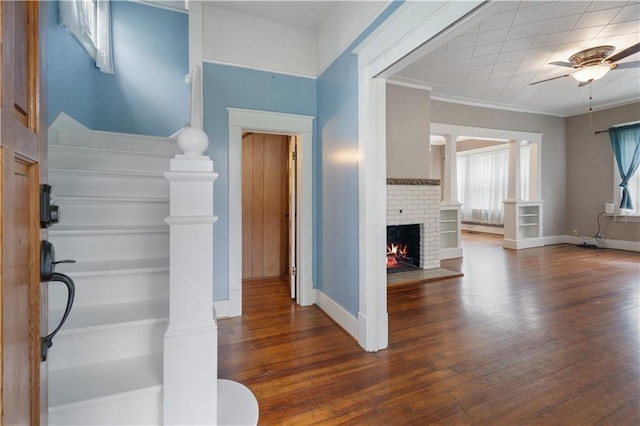 704 Lincoln St, Coffeyville, KS 67337 - entrance foyer featuring wood finished floors, ceiling fan, a fireplace, and crown molding