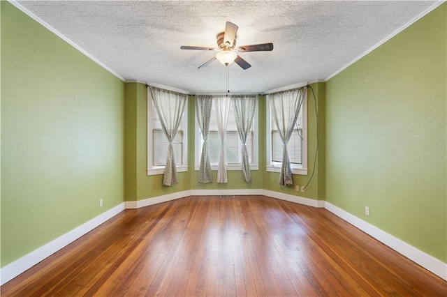 704 Lincoln St, Coffeyville, KS 67337 - empty room featuring a ceiling fan, wood-type flooring, crown molding, and a textured ceiling