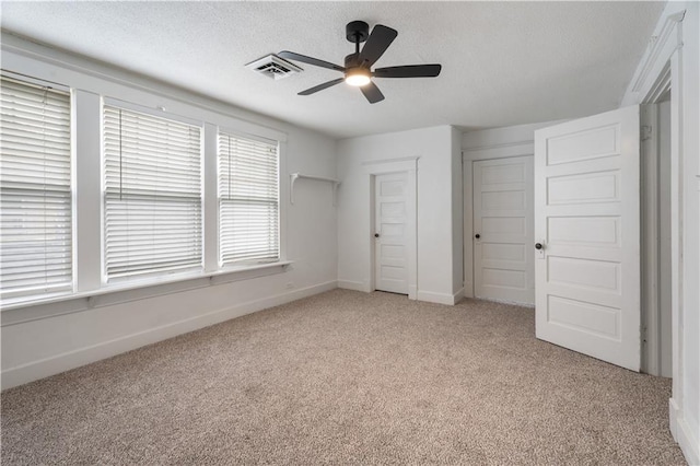 704 Lincoln St, Coffeyville, KS 67337 - unfurnished bedroom with light colored carpet, a textured ceiling, and ceiling fan
