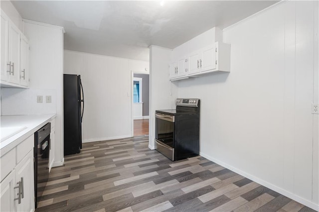 704 Lincoln St, Coffeyville, KS 67337 - kitchen featuring black appliances, wood finished floors, white cabinets, and light countertops