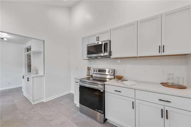 9521 W 60th St, Merriam, KS 66203 - kitchen featuring appliances with stainless steel finishes, tasteful backsplash, a towering ceiling, and white cabinetry