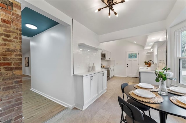 9521 W 60th St, Merriam, KS 66203 - dining area with healthy amount of natural light, a chandelier, and lofted ceiling