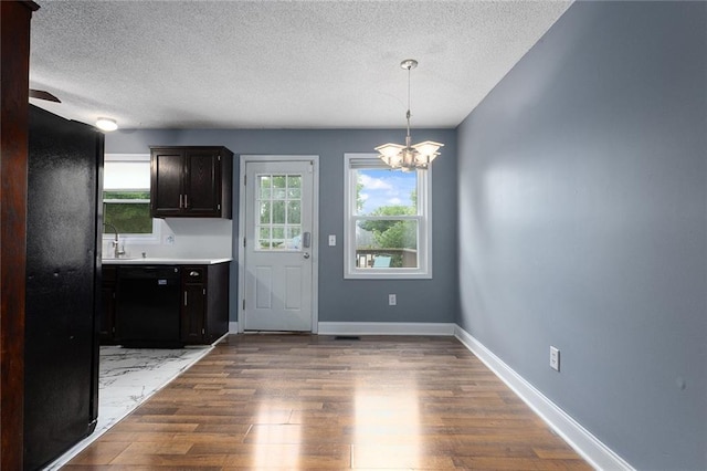 33145 W 88th Ter, De Soto, KS 66018 - kitchen featuring a textured ceiling, a chandelier, wood finished floors, decorative light fixtures, and light countertops