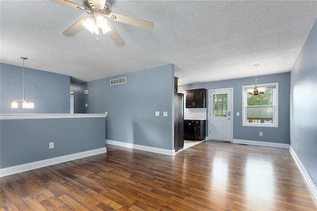 33145 W 88th Ter, De Soto, KS 66018 - unfurnished living room with a chandelier, a textured ceiling, dark wood finished floors, and a ceiling fan