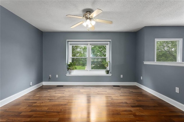 33145 W 88th Ter, De Soto, KS 66018 - empty room with plenty of natural light, a ceiling fan, wood finished floors, and a textured ceiling