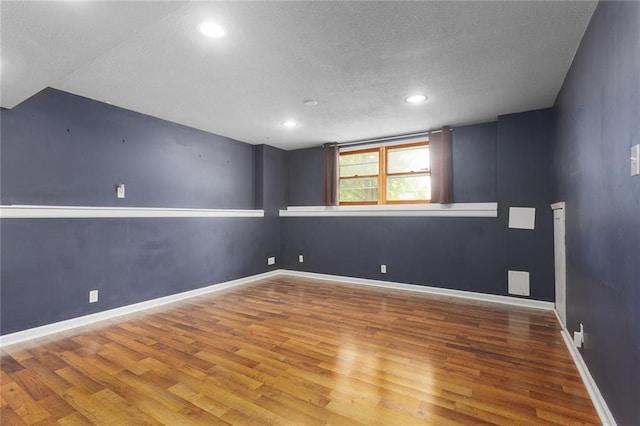 33145 W 88th Ter, De Soto, KS 66018 - empty room featuring wood finished floors, a textured ceiling, and recessed lighting
