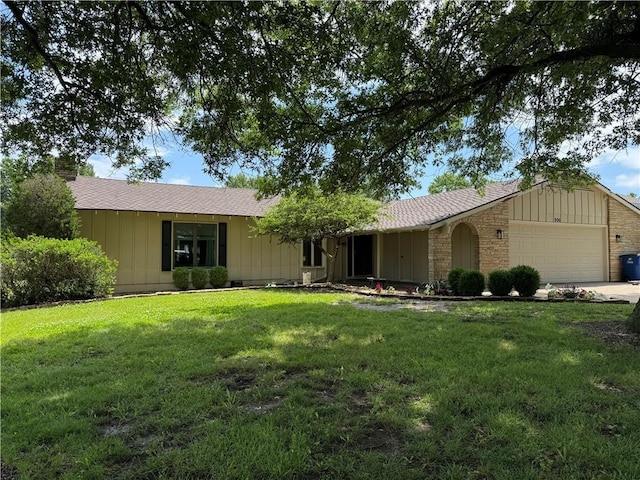 906 S Denman, Chanute, KS 66720 - ranch-style house with board and batten siding, an attached garage, a front yard, and a chimney
