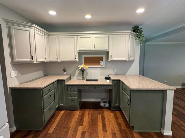 906 S Denman, Chanute, KS 66720 - kitchen with a peninsula, dark wood finished floors, built in desk, ornamental molding, and recessed lighting