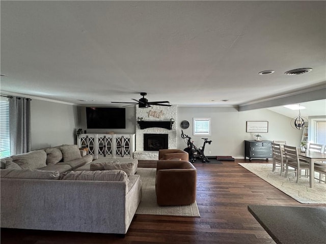 906 S Denman, Chanute, KS 66720 - living area featuring a fireplace, ceiling fan, dark wood-type flooring, and ornamental molding