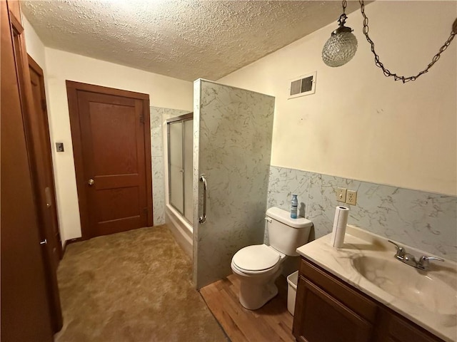 529 S Business Highway 13, Lexington, MO 64067 - bathroom featuring a textured ceiling, vanity, a wainscoted wall, and enclosed tub / shower combo