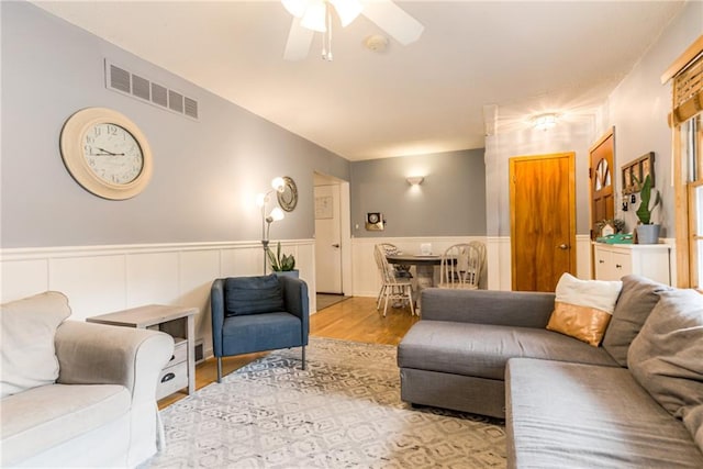 702 Green St, Lees Summit, MO 64063 - living room featuring ceiling fan, wainscoting, and wood finished floors