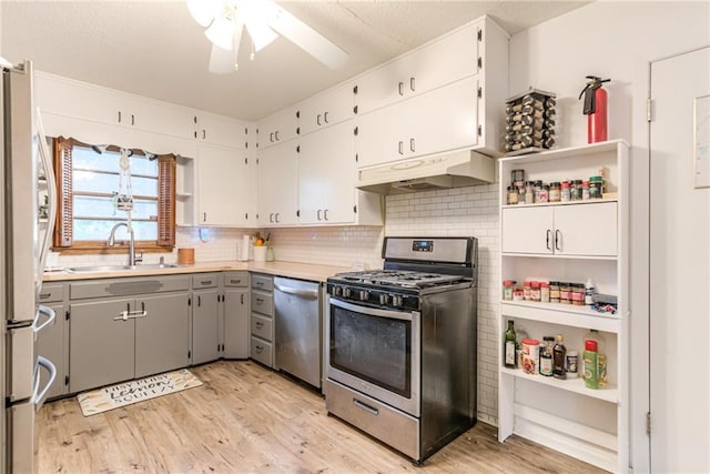 702 Green St, Lees Summit, MO 64063 - kitchen featuring stainless steel appliances, under cabinet range hood, ceiling fan, and decorative backsplash