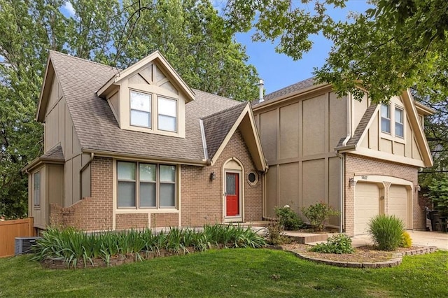 1467 E Orleans Dr, Olathe, KS 66062 - english style home with brick siding, a garage, concrete driveway, a front yard, and roof with shingles