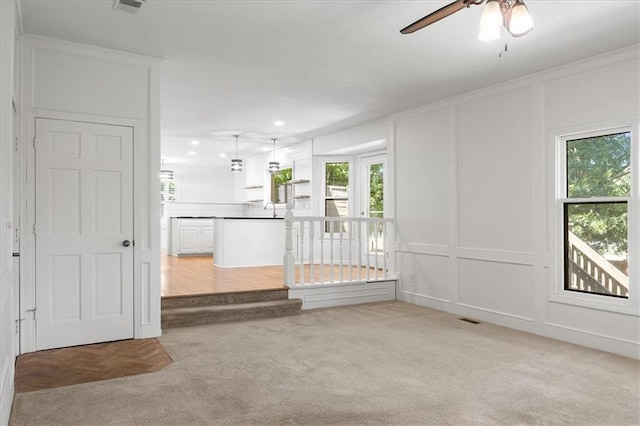 1467 E Orleans Dr, Olathe, KS 66062 - unfurnished living room featuring a decorative wall, light colored carpet, ceiling fan, and recessed lighting