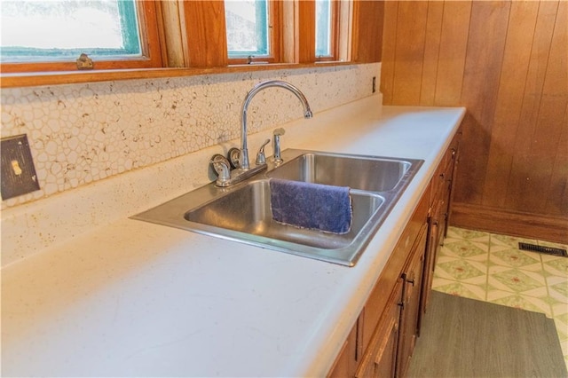 708 Osage St, Neodesha, KS 66757 - kitchen with brown cabinets, wood walls, backsplash, and light countertops