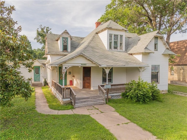708 Osage St, Neodesha, KS 66757 - view of front of property with covered porch, a front yard, and roof with shingles