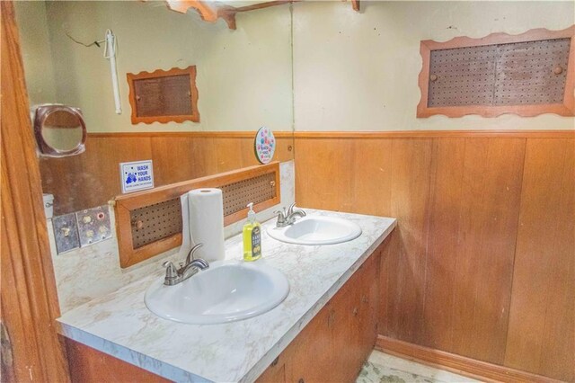 708 Osage St, Neodesha, KS 66757 - full bath with double vanity, wainscoting, and wooden walls