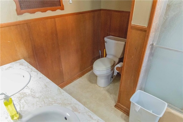 708 Osage St, Neodesha, KS 66757 - full bath featuring double vanity, a shower with shower door, wooden walls, and a wainscoted wall