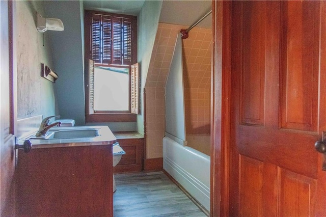 708 Osage St, Neodesha, KS 66757 - bathroom with vanity, washtub / shower combination, and wood finished floors