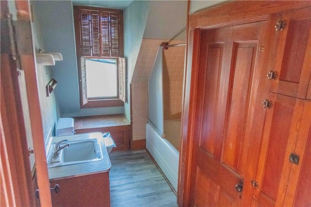 708 Osage St, Neodesha, KS 66757 - bathroom featuring vanity, shower / bathtub combination, and wood finished floors