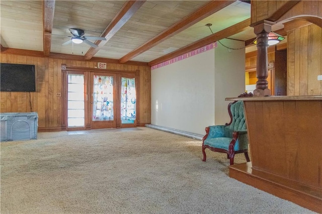 708 Osage St, Neodesha, KS 66757 - unfurnished room with beamed ceiling, wooden walls, ceiling fan, carpet, and ornate columns