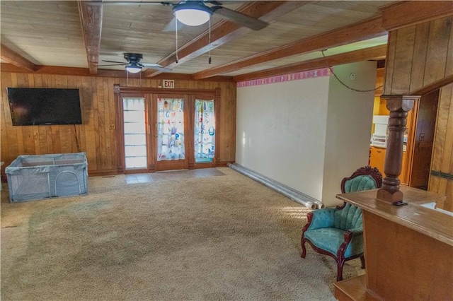 708 Osage St, Neodesha, KS 66757 - living area with beam ceiling, a ceiling fan, wood walls, and carpet