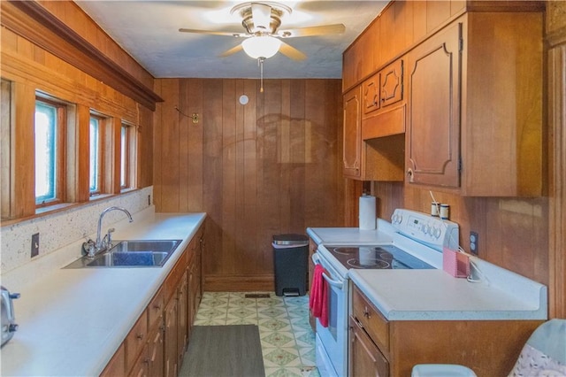708 Osage St, Neodesha, KS 66757 - kitchen with white electric range, brown cabinets, light countertops, wooden walls, and ceiling fan