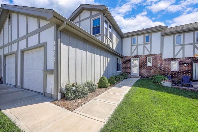 7103 Mastin St, Merriam, KS 66203 - view of front of house featuring board and batten siding, a garage, a front yard, driveway, and brick siding